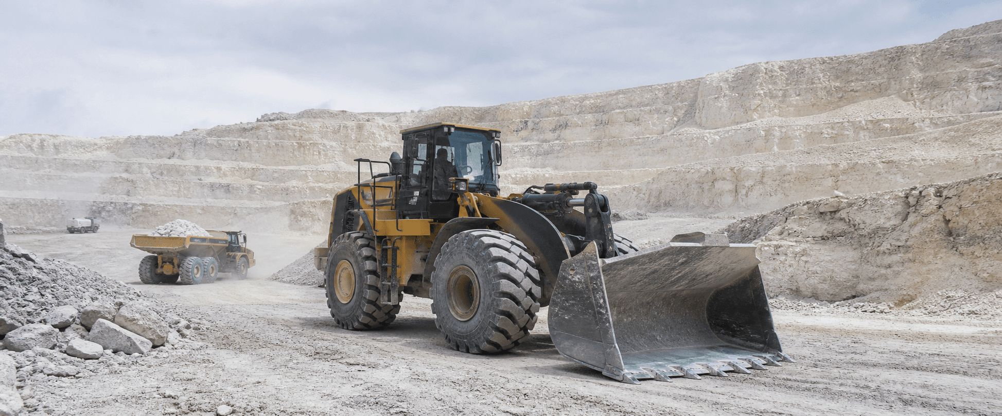 Wheel loader and articulated dump truck operating in a limestone quarry